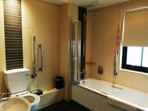 uma casa de banho com um WC, uma banheira e um lavatório. em The BlueBell Hotel em Neath