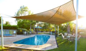 a pool under a canopy with a table and chairs at Winbi River Resort Holiday Rentals in Moama