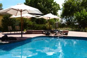 a swimming pool with two umbrellas and a swimming pool at Winbi River Resort Holiday Rentals in Moama