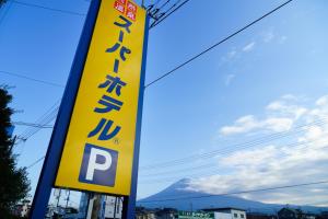 富士宮的住宿－Super Hotel Fujinomiya， ⁇ 上的一个黄色标志,背景是山
