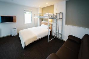 a hotel room with a bunk bed and a couch at Super Hotel Fujinomiya in Fujinomiya +91 photos