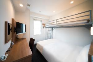 Habitación de hotel con litera y escritorio en Super Hotel Fujinomiya, en Fujinomiya