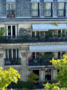 an old building with balconies and plants on it at Hotel Studia in Paris
