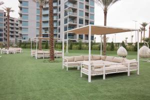 a group of chairs and umbrellas on a lawn at Fully Furnished Studio - MAG 560 - 621 in Dubai