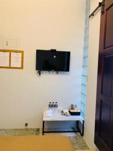 a room with a table with a tv on a wall at OYAJI Guesthouse 歐野基民家宿泊 in Tainan +41 photos