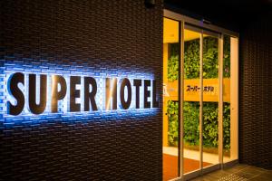 a super coffee sign on the side of a brick building at Super Hotel Fujinomiya in Fujinomiya