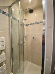 a shower with a glass door in a bathroom at Hotel Studia in Paris