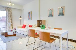 a living room with a white table and chairs at Eclectic 1BR in Pantheon Boulevard by Deluxe Holiday Homes in Dubai
