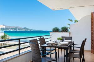 a table and chairs on a balcony with a view of the ocean at Bellavista in Port d'Alcudia