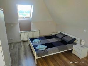 um quarto com uma cama com um cobertor xadrez e uma janela em Górskie Marzenie em Przeciszów
