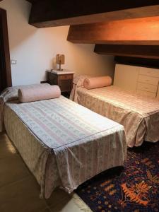 1 dormitorio con 2 camas, mesa y alfombra en Abruzzo Forte e Gentile en Castel di Ieri