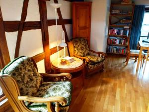 sala de estar con 2 sillas y mesa en Ferienhaus Marré - mit Grill, Feuerstelle und Gartensauna, en Waldbrunn