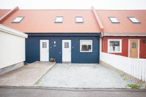 a blue garage with a red roof and white doors at Lovely house in Tórshavn in Tórshavn