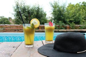 zwei Getränke auf einem Holztisch neben einem Hut in der Unterkunft Guest house BULGARKA in Dibich