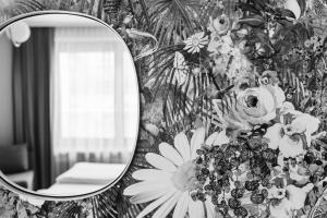 um espelho numa parede com um papel de parede floral em Altstadthotel Weisse Taube em Salzburgo
