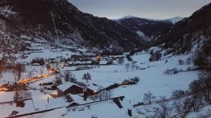 un pequeño pueblo en una montaña cubierta de nieve en Dúplex Àreu, Pallars, en Àreu