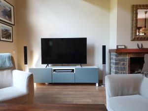 una sala de estar con TV de pantalla plana en un armario blanco en Dúplex Àreu, Pallars, en Àreu