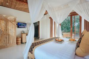 a bedroom with a bed with a canopy at Sitala Suite in Ubud