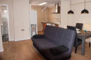 ein Wohnzimmer mit einem Sofa und einem Tisch in der Unterkunft STAY TOLETVM Apartametos turísticos in Toledo