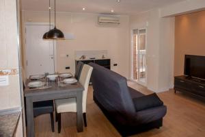 a living room with a table and a couch and a chair at STAY TOLETVM Apartametos turísticos in Toledo