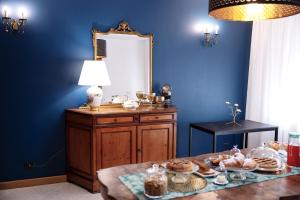 Mirò B&B في أكوافيفا ديلي فونتي: غرفة زرقاء مع طاولة عليها طعام