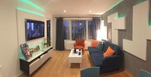 a living room with a blue couch and a tv at Blarmore Apartment Inverness in Inverness