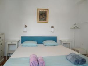 a bedroom with a bed with purple slippers on it at Apartment Emma in Mali Lošinj