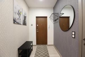 a hallway with a mirror and a wooden door at Comfy 2 Room Apartment - Free Parking - 350Mbps WiFi - Netflix in Kaunas