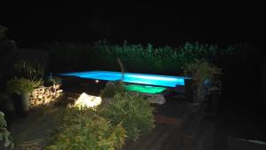 a swimming pool in the yard at night at Chambre privée tout confort in Conlie