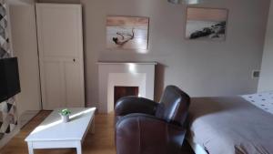 a bedroom with a bed and a chair and a table at Chambre privée tout confort in Conlie