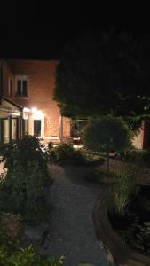 a house at night with a garden and a building at Chambre privée tout confort in Conlie