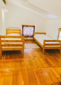 2 letti in una camera con pavimenti in legno di Počitniška hiša Lazar a Kobarid