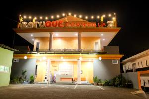 a building with a sign on top of it at night at Batuque Town Villa 2 in Batu