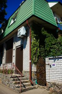 uma casa com um telhado verde com uma porta em КЛУБ B55 em Dnipro