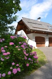 a building with pink flowers in front of it at Fewo Martiner in Ferndorf