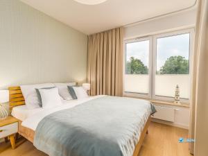 コウォブジェクにあるLazar Apartamenty Nadmorskie Tarasyの大きなベッドと大きな窓のある寝室 +140枚の写真