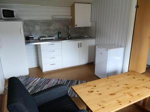 a kitchen with a table and chairs and a refrigerator at Fjordbotn Camping in Galnslåtta