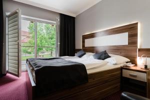 a bedroom with a large bed and a window at Hotel Menhard in Vrbov