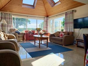 a living room with couches and a table at Ashlea Bungalow in Portrush