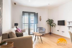 a living room with a couch and a tv at Corazon del Mar - FREE PARKING by Cadiz Time in Cádiz