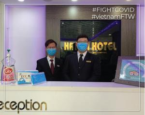 two men wearing face masks at a convention at Ha Noi Hotel near Tan Son Nhat International Airport in Ho Chi Minh City