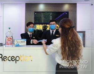 Ha Noi Hotel near Tan Son Nhat International Airport في مدينة هوشي منه: شخصان يلبسان أقنعة الوجه على منضدة