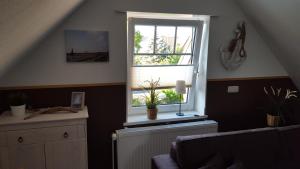 a living room with a window with a radiator and plants at Ferienwohnung Elbkoje in Brunsbüttel