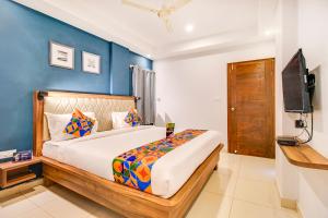 1 dormitorio con 1 cama con pared azul en FabHotel The Sun Suites Vinayaka Nagar, en Yelahanka