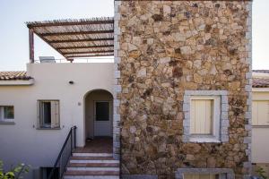 a building with a stone wall and a stone staircase at Residence Ea Bianca in Baja Sardinia