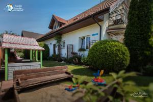 a house with a wooden bench in the yard at Morski Bobolin in Bobolin