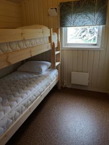 a bunk bed in a room with a window at Fjordbotn Camping in Galnslåtta