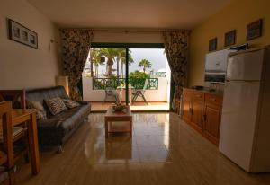 ein Wohnzimmer mit einem Sofa und einem Kühlschrank in der Unterkunft Paradise Club in Puerto del Carmen