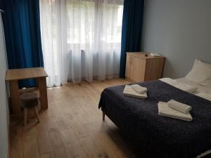 um quarto com uma cama com duas toalhas em MAGNEZJA em Karpacz