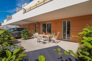 eine Terrasse mit einem Tisch und Stühlen vor einem Haus in der Unterkunft Villa Seeadler in Börgerende-Rethwisch